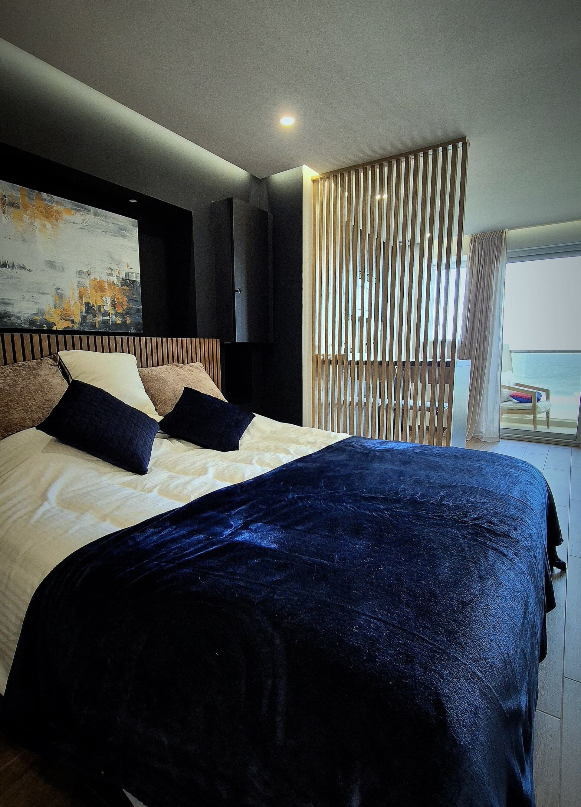 Chambre avec séparation en lattes de bois et vue vers la terrasse